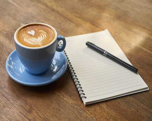 A relaxed notebook and coffee cup on a wooden table in Valencia