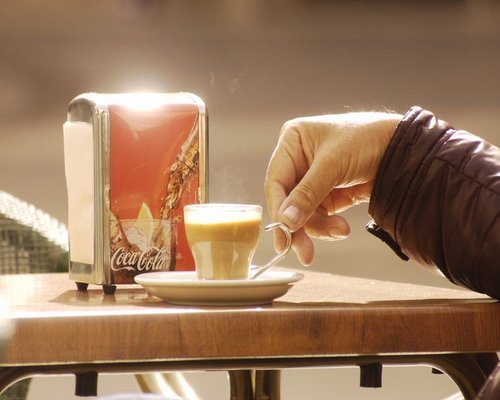 Person enjoying a relaxed morning coffee outdoors in Spain